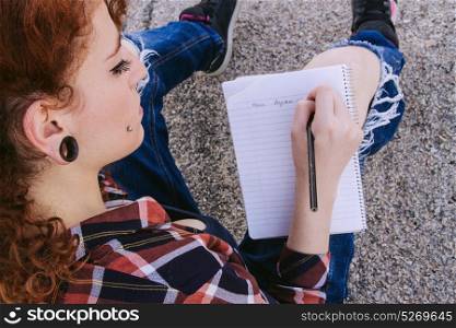 Young redhead woman writing a letter