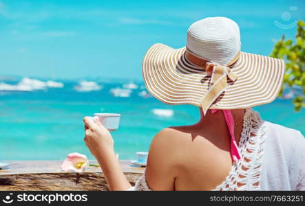 Young, relaxed woman drinking coffee in a beach bar
