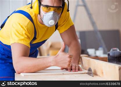 Young repairman carpenter working cutting wood on circular saw