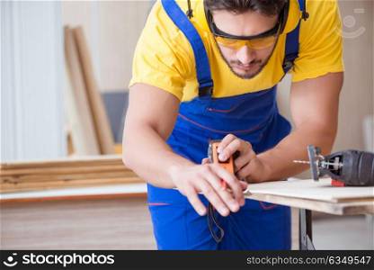 Young repairman carpenter working cutting wood on circular saw
