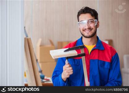 Young repairman carpenter working with clamps