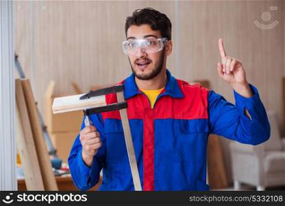 Young repairman carpenter working with clamps