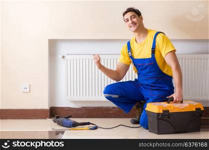 Young repairman contractor repairing heating panel