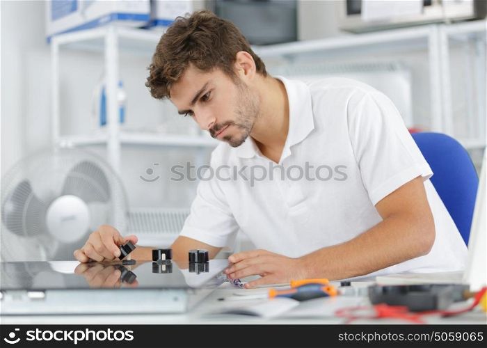 young repairman installing induction cooker in kitchen