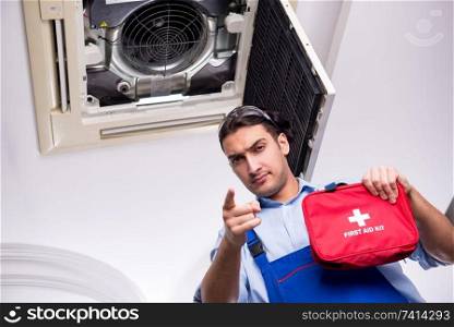 Young repairman repairing ceiling air conditioning unit 