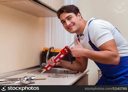 Young repairman working at the kitchen