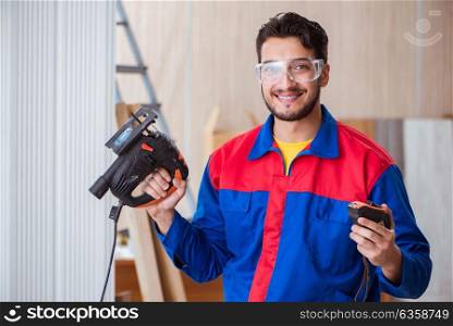 Young repairman working with a power saw sawing