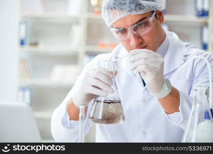 Young researcher scientist doing a water test contamination expe. Young researcher scientist doing a water test contamination experiment in the laboratory