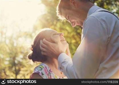 Young romantic couple flirting in sunshine. Dating, love, romance, vintage flare.. Young romantic couple flirting in sunshine. Vintage love