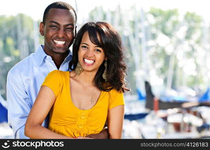 Young romantic couple hugging and standing at harbor