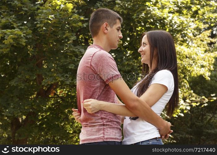 Young romantic couple in park at sunny day