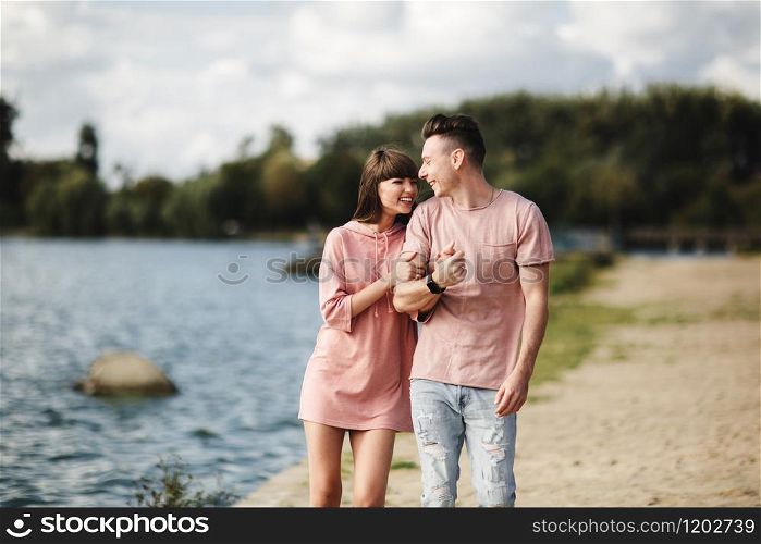 Young romantic couple is having fun in summer sunny day near the lake. Enjoying spending time together in holiday. Man and woman are hugging.. Young romantic couple is having fun in summer sunny day near the lake. Enjoying spending time together in holiday. Man and woman are hugging