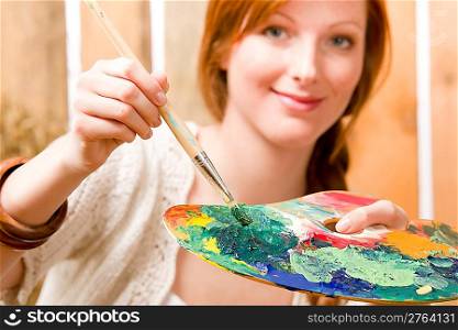 Young romantic redhead woman hold color palette in barn