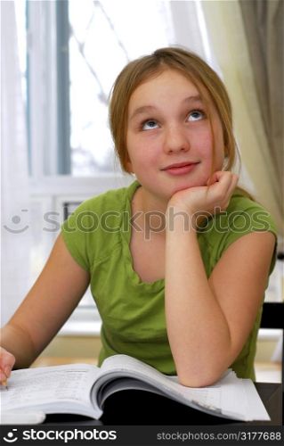 Young school girl doing homework at her desk