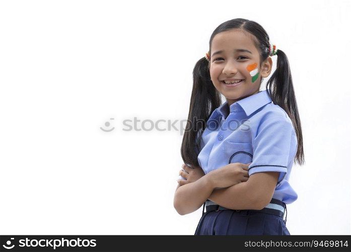 young school girl with flag drawn on her cheeks standing with folded hands, independence day