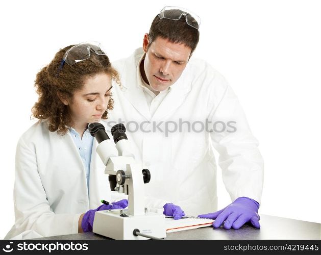 Young science student works in lab while professor supervises. Isolated on white.