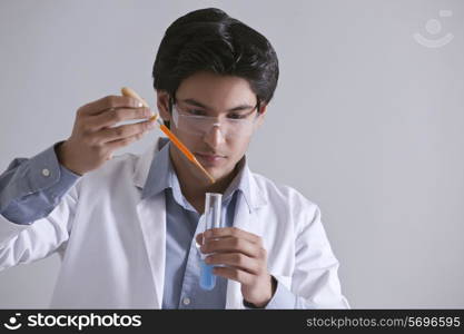 Young scientist adding liquid to the test tube
