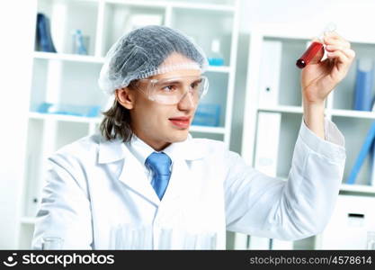 Young scientist in white uniform working in laboratory