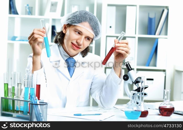 Young scientist in white uniform working in laboratory