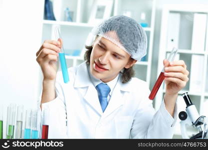 Young scientist in white uniform working in laboratory