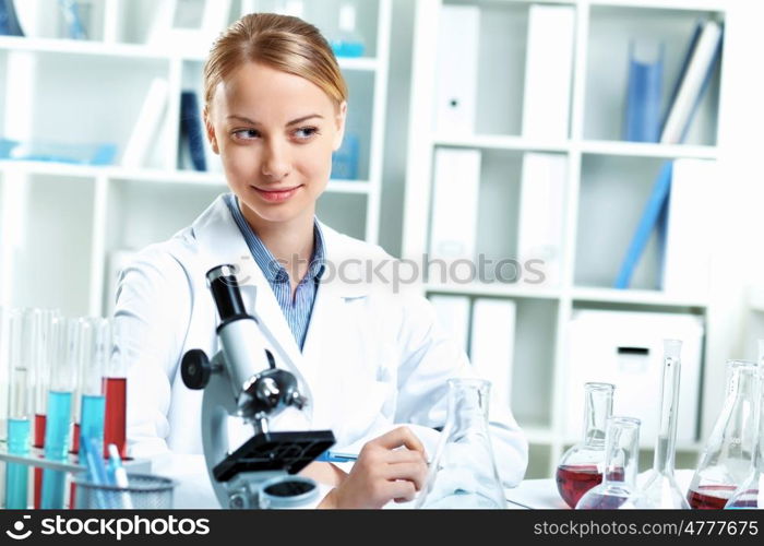 Young scientist in white uniform working in laboratory