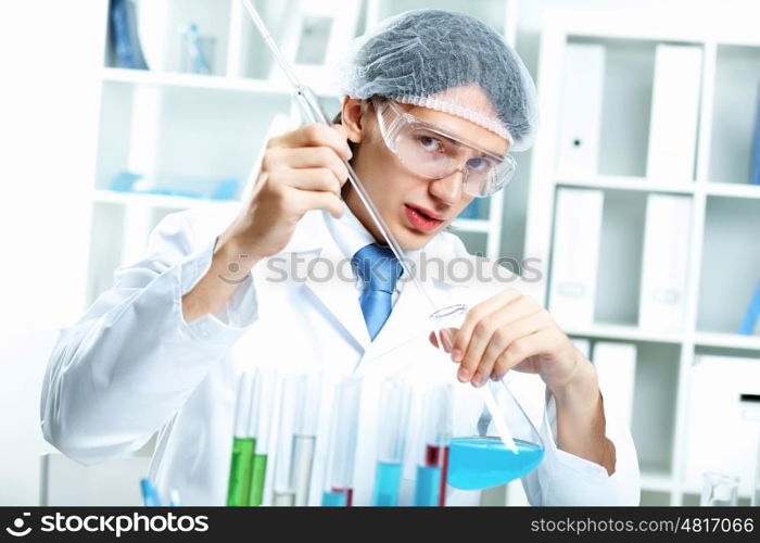 Young scientist in white uniform working in laboratory