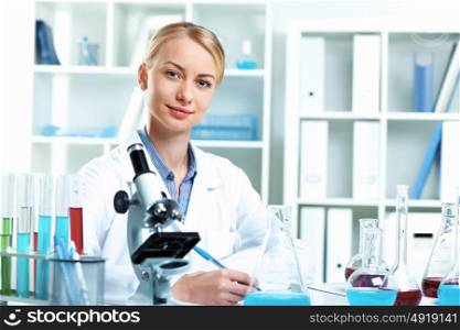 Young scientist in white uniform working in laboratory