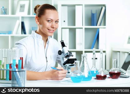 Young scientist in white uniform working in laboratory