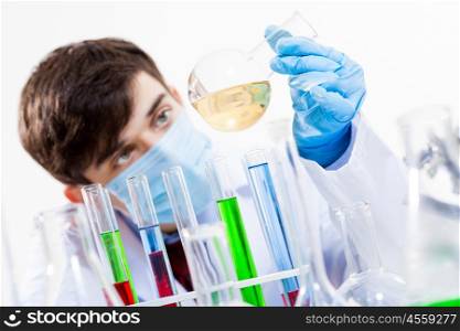 Young scientist making chemical tests in laboratory. In the name of science