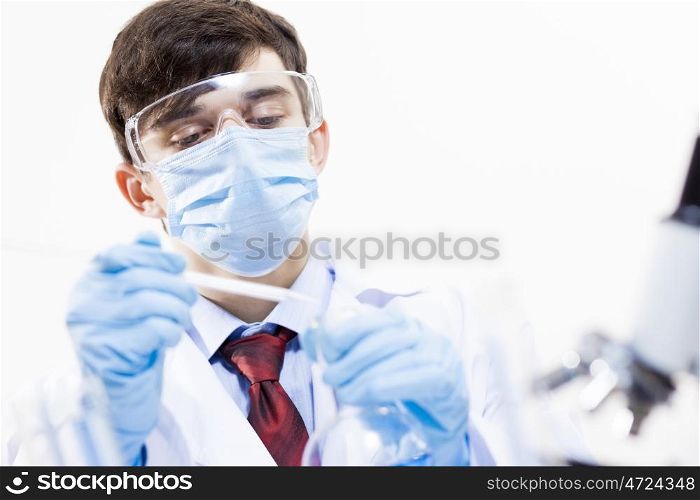 Young scientist making chemical tests in laboratory. In the name of science