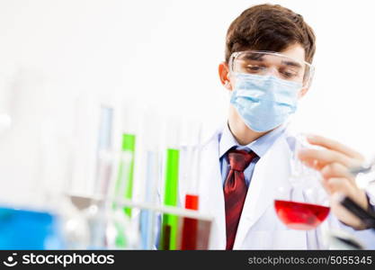 Young scientist making chemical tests in laboratory. In the name of science