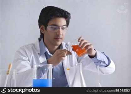 Young scientist pouring liquid in a test tube