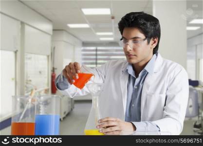 Young scientist pouring solution in a flask