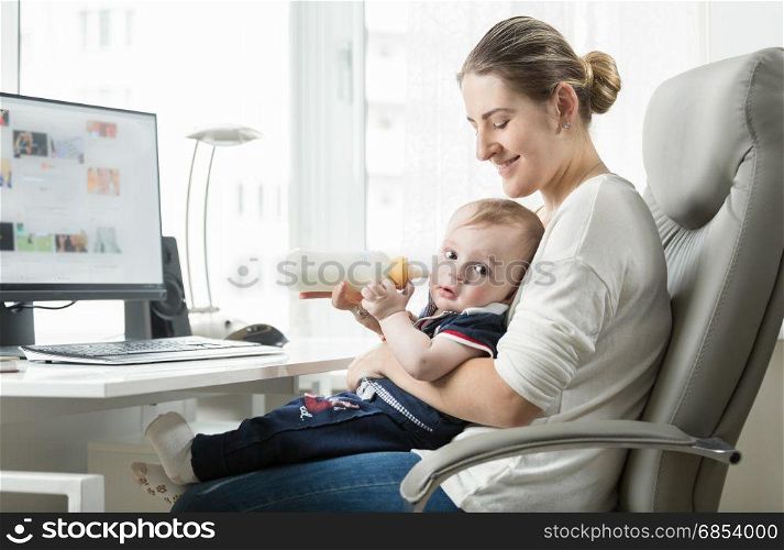 Young self employed mother working at home and taking care of her baby