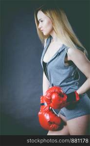 Young sensual woman, blonde attractive girl wearing red punch boxing gloves. Sport fitness and power concept.. Beautiful woman with red boxing gloves