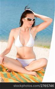 Young sexy bikini model relaxing with sunglasses on beach
