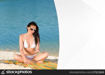 Young sexy bikini model relaxing with sunglasses on beach copyspace