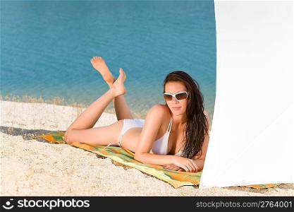Young sexy bikini model relaxing with sunglasses on beach copyspace