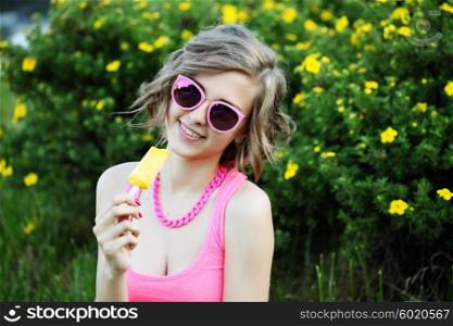Young sexy blonde girl eating orange ice cream in summer hot weather in mirror sunglasses have fun and good mood and smiling