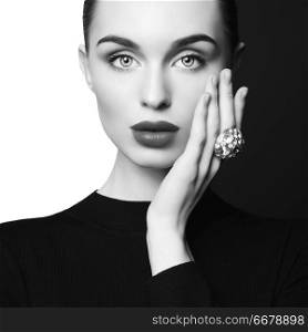 young sexy lady with big ring with diamonds in black-and-white studio. beautiful woman with perfect lips and black lipstick poses in photostudio. Fashion portrait of fashionable model.