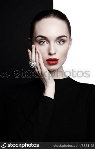 young sexy lady with big ring with diamonds in black-and-white studio. beautiful woman with perfect lips and red lipstick poses in photostudio. Fashion portrait of fashionable model.