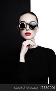 young sexy lady with black stylish sunglasses in black-and-white studio. beautiful woman with perfect lips and red lipstick pose in photostudio. Fashion portrait of fashionable model.