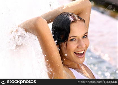 Young sexy woman bathes in a city fountain