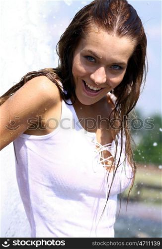 Young sexy woman bathes in a city fountain
