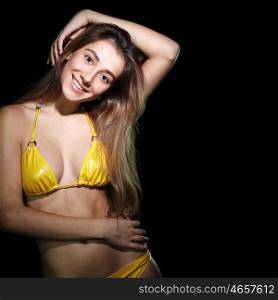 Young sexy woman in yellow bikini in dark studio&#xA;