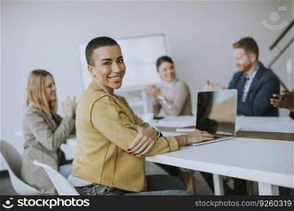 Young short hair business woman sitting in the office and using laptop with her team