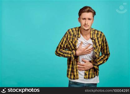 Young sick man portrait, blue background, emotion. Face expression, male person looking on camera in studio, emotional concept, positive feelings. Young sick man portrait, blue background, emotion