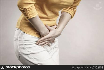 Young sick woman with hands holding pressing her crotch lower abdomen. Medical or gynecological problems, healthcare concept. Woman with hands holding her crotch