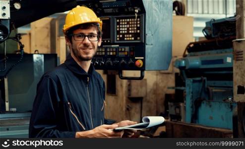 Young skillful factory worker or engineer close up portrait in factory . Industry and engineering concept .. Young skillful factory worker or engineer close up portrait in factory