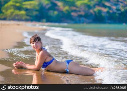 Young skinny girl in a bathing suit and waves